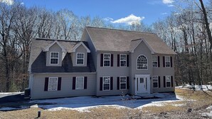 A two-story house with a symmetrical facade, a central entrance with a door, and a small porch area. - Cozy getaway in the Poconos — 5minutes away from all your favorite attractions ! (Stroudsburg)