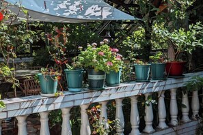 Un balcone con piante in vaso e ringhiera bianca.