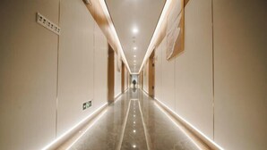 Un long couloir étroit, doté d’un plancher poli et d’un éclairage encastré.