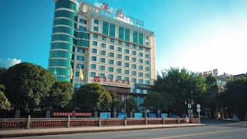 Un hotel de varios pisos con fachada curva, una entrada destacada y cielo despejado.