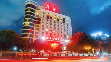 A multi-story hotel with a prominent red sign, a well-lit facade, and a modern architectural design.