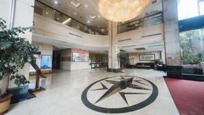 Un hall d’entrée spacieux, doté d’un grand motif décoratif au sol, de plusieurs niveaux et d’un luminaire suspendu particulièrement remarquable.