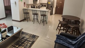 Cozinha moderna com ilha central, banquetas e mesa de jantar com cadeiras.