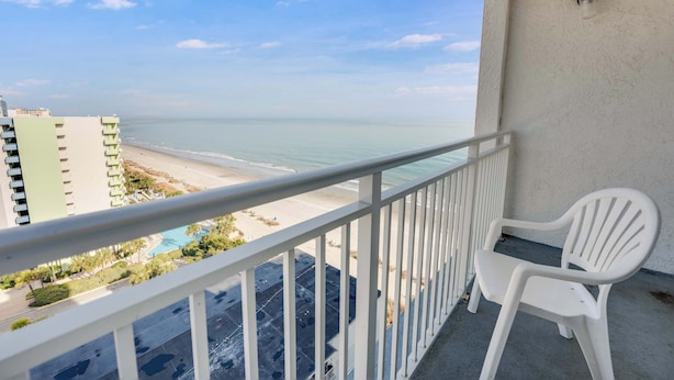 A balcony with a white railing overlooking a beach and a pool. - Beautiful High-Floor - Ocean Views Newly Renovated (Myrtle Beach)