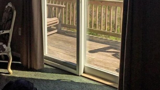 Quarto com uma grande porta de vidro deslizante que dá para um deck externo.