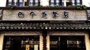 A building with a traditional Chinese architectural style, featuring a tiled roof and a brick facade. - The 2 90's Guys Inn (Tongxiang)