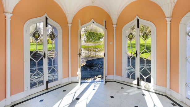 A corridor with arched ceilings and a view of a garden through a glass door. - Halecat House - Large Georgian House with Garden (Dog-friendly). (Witherslack)