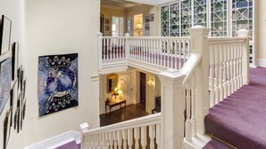 A multi-level interior with a staircase, a dining area, and a library with glass display cases. - Halecat House - Large Georgian House with Garden (Dog-friendly). (Witherslack)