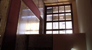 A room with a window, a metal beam, and a wall with a paper on it. - Hotel Plaza Ungheria (Palermo)
