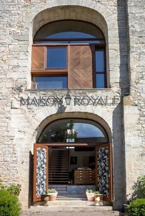 Un edificio de piedra con un letrero que dice "MAISON ROYALE".