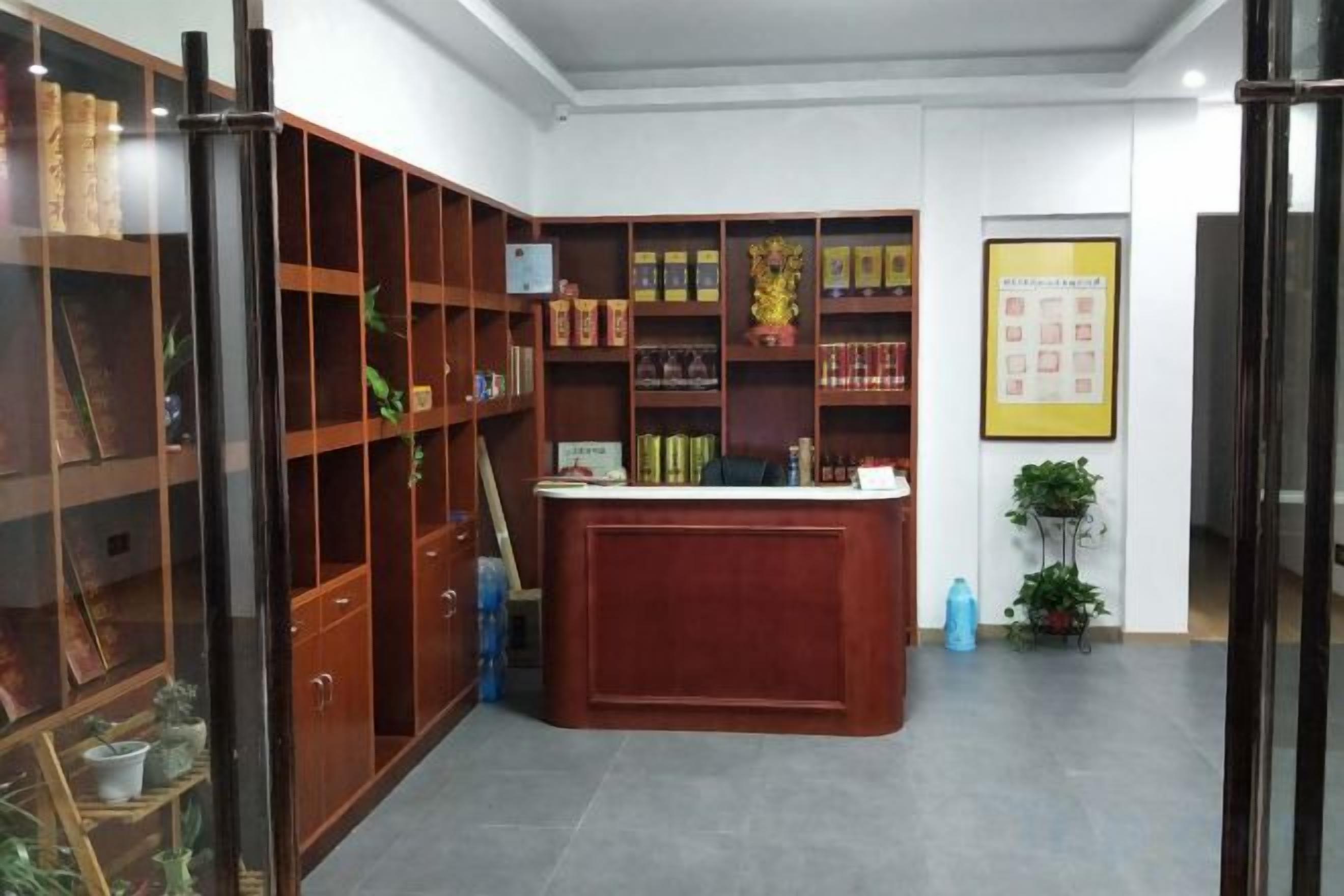 A reception area with a wooden desk, shelves with books, and a framed picture on the wall.