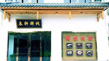 A traditional building with a tiled roof and a signboard with Chinese characters.