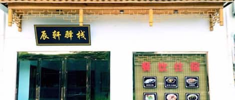 A traditional building with a tiled roof and a signboard with Chinese characters.