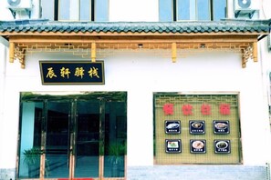 A traditional building with a tiled roof and a signboard with Chinese characters. - Chen Xuan Yi Zhai (Jiu Hua Mountain Tourist Service Center Store) (Qingyang)