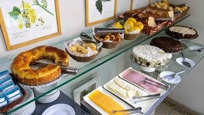 Un buffet proposant une variété de plats, notamment des gâteaux, des pâtisseries et du pain, présentés sur un comptoir en verre.