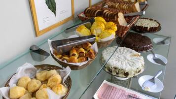 Un bufé con diversos alimentos, como pan, pasteles y postres.