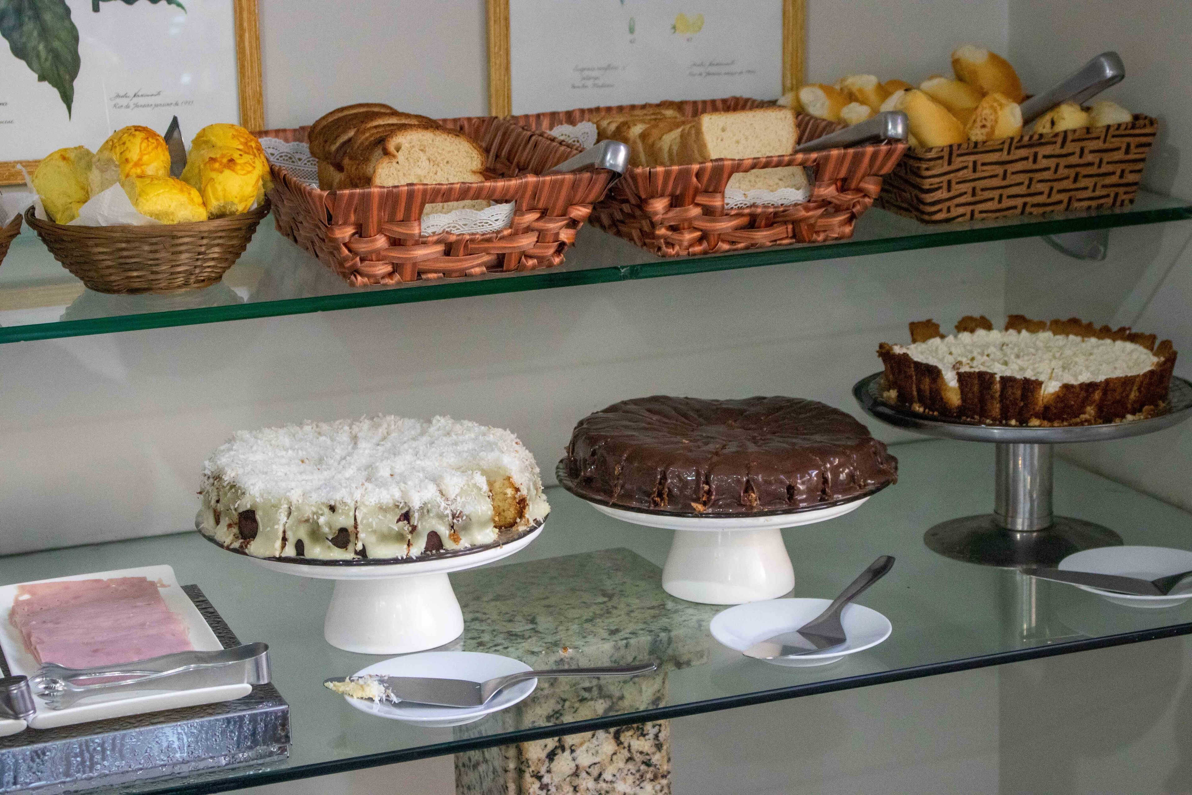 Een presentatie van diverse gebakjes en desserts op een glazen plank.