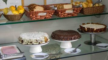 Een presentatie van diverse gebakjes en desserts op een glazen plank.