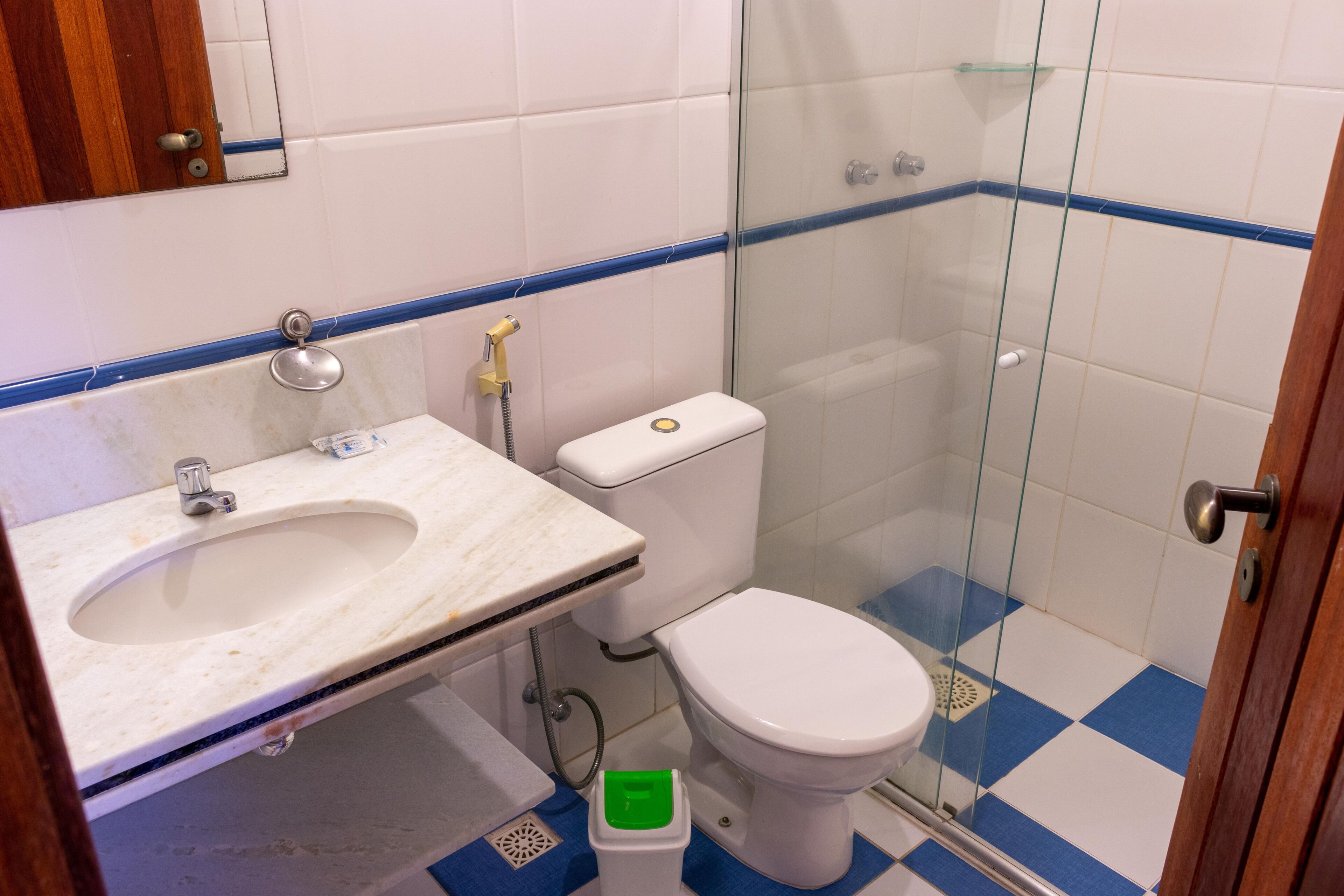 A bathroom with a sink, toilet, and glass shower enclosure.
