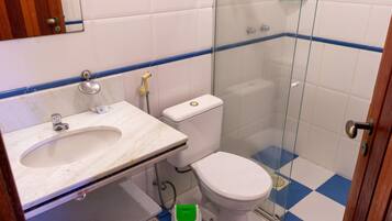 A bathroom with a sink, toilet, and glass shower enclosure.