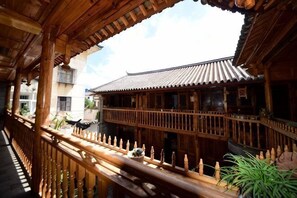 A traditional wooden building with a balcony, wooden railings, and a tiled roof.
