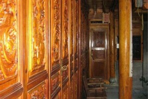 Un pasillo con paneles de madera decorativos y una puerta de madera al final.