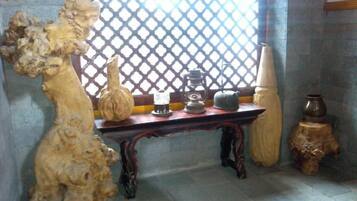 A room with a wooden table, decorative vases, and a lattice window.