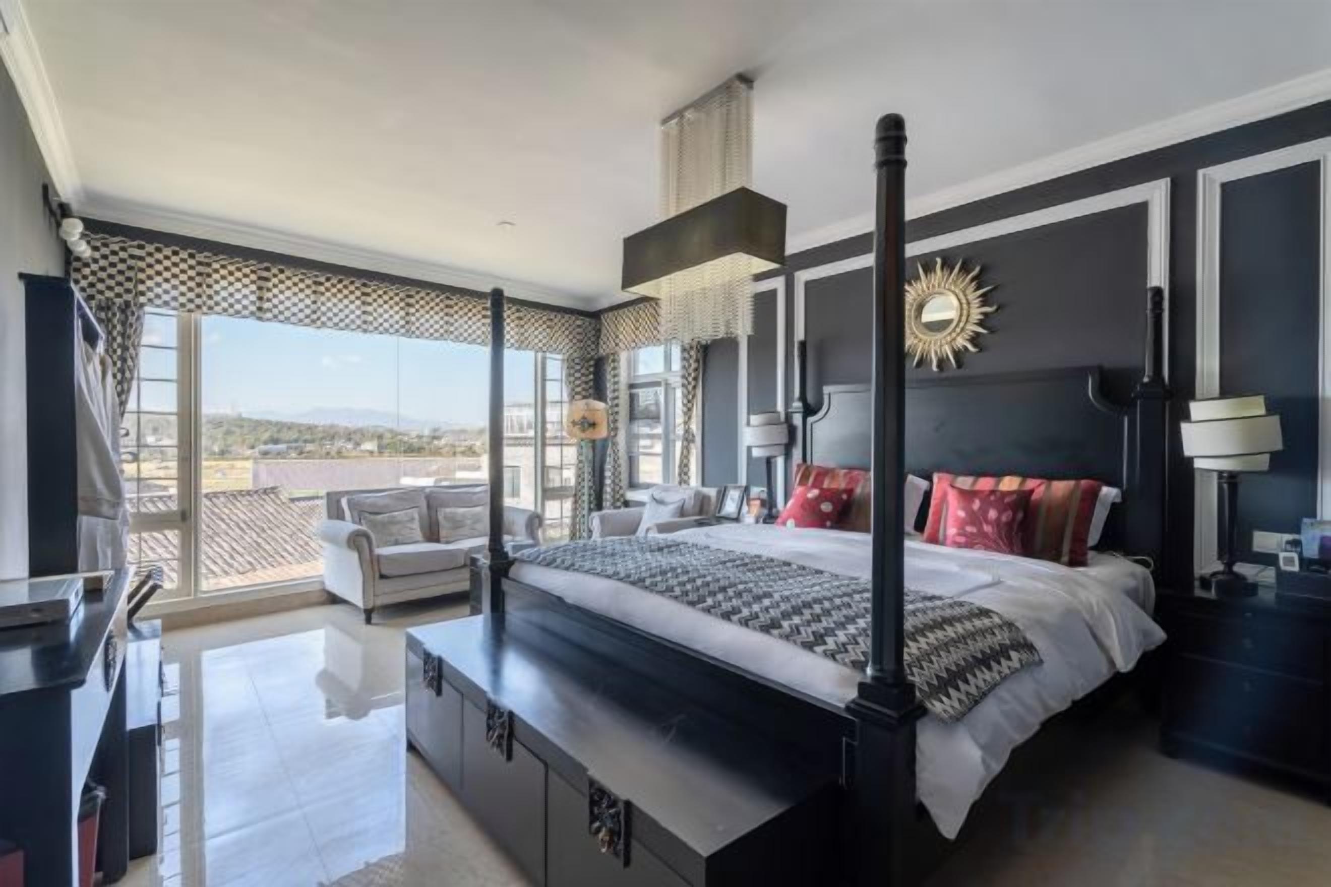 Un dormitorio moderno con una cama grande, un escritorio y un balcón con vistas.