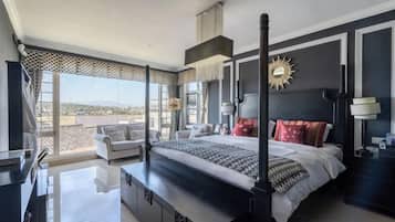 Un dormitorio moderno con una cama grande, un escritorio y un balcón con vistas.
