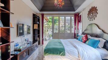 Un dormitorio moderno con una cama grande, un televisor, una estantería y vistas al exterior.