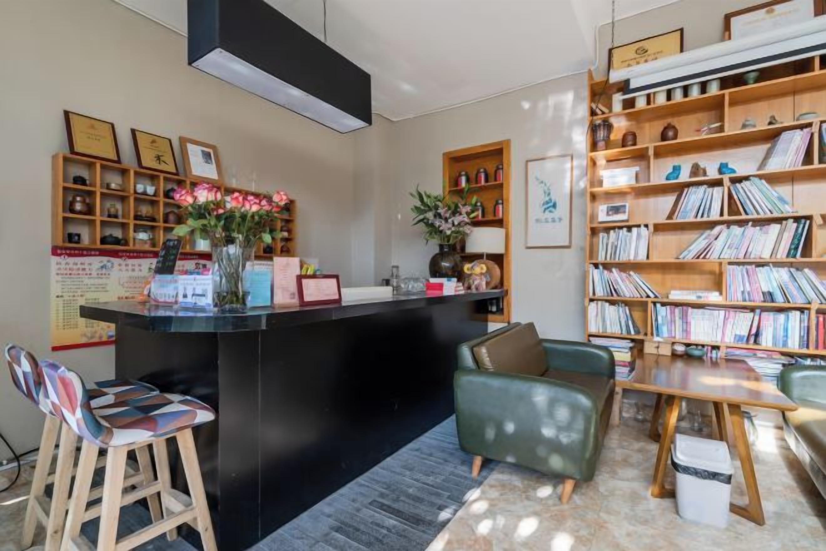 Ein Empfangsbereich mit Theke, Sitzgelegenheiten und einem Bücherregal.