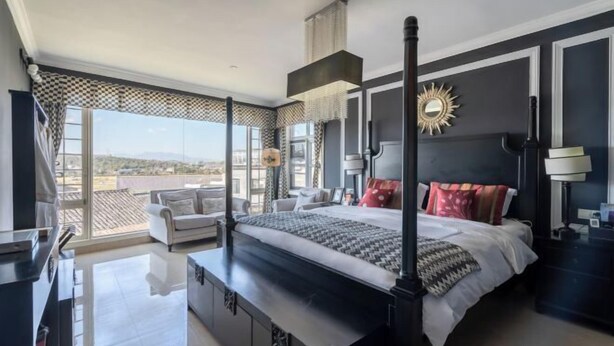 A modern bedroom with a large bed, a view of the city, and a balcony. - Qingtian Yashe Inn (Tengchong)