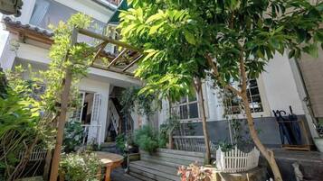 A courtyard with a wooden pergola, a small table, and a white picket fence.