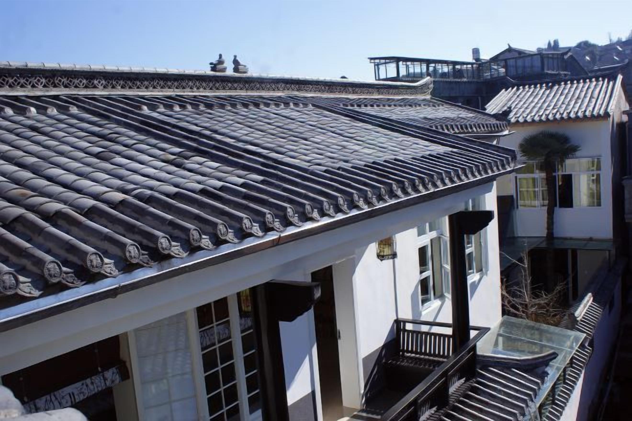 A traditional building with a tiled roof, a balcony, and a staircase.