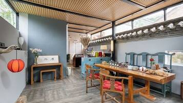 Un comedor con una mesa y sillas de madera, un banco y un muro decorativo.