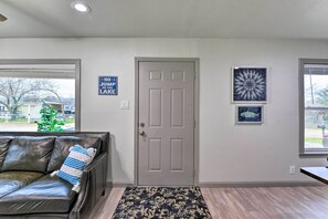 Ein Zimmer mit einer Ledersofa, einer Tür und zwei gerahmten Bildern an der Wand.