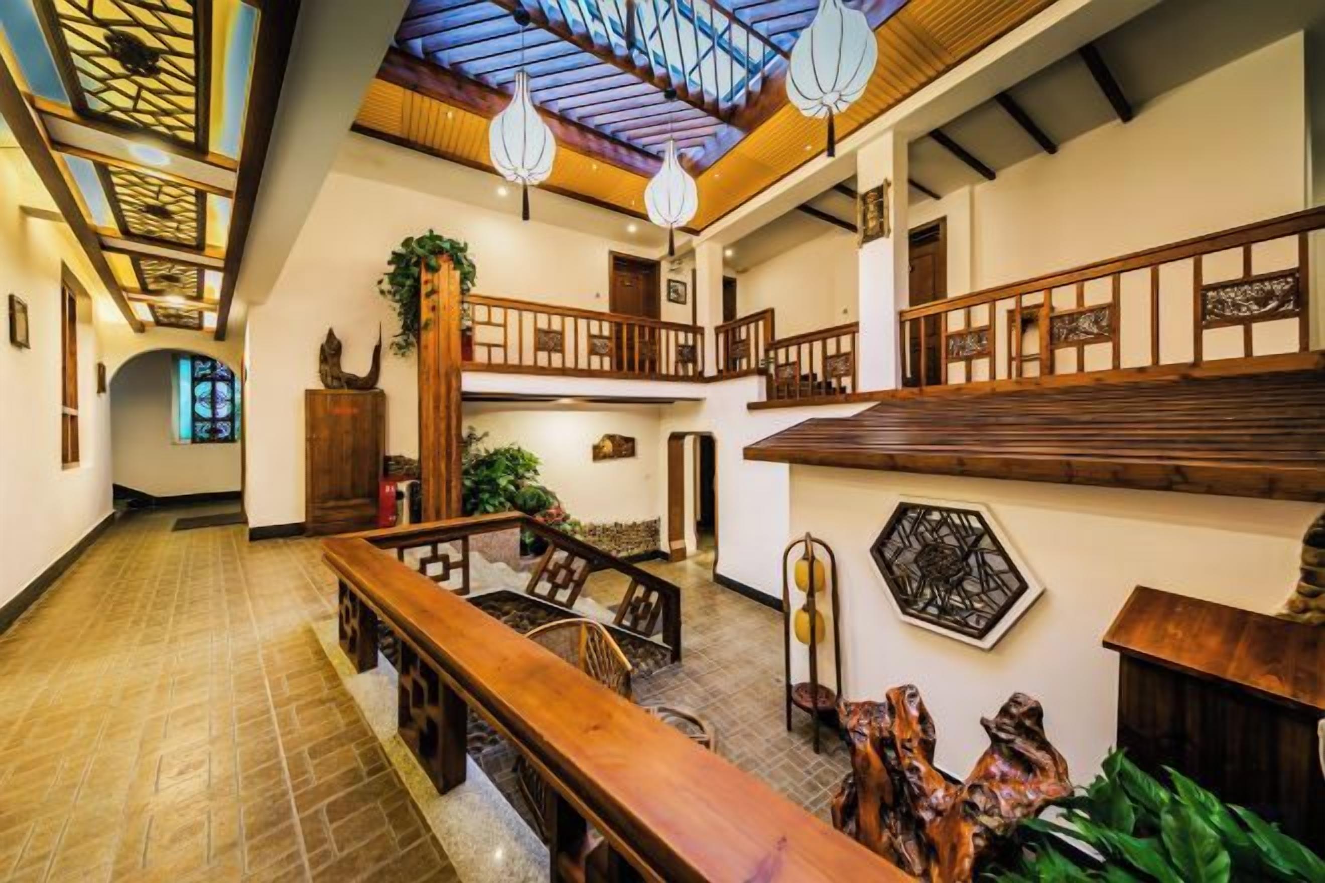 A spacious lobby with a high ceiling, wooden benches, and a staircase.
