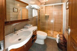 Et badeværelse med vask, toilet og brusekabine.