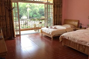 A bedroom with two beds, a balcony, and a view of greenery. - Laozheng Homestay (Yangshuo)