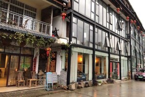 A traditional building with a balcony, large windows, and outdoor seating. - Laozheng Homestay (Yangshuo)