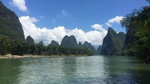 A river surrounded by forested hills. - Laozheng Homestay (Yangshuo)