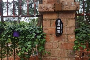 A brick wall with a black sign. - Yunshui Hulin Inn Puzhehei (Qiubei)
