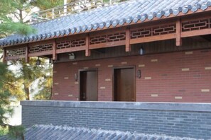 A traditional building with a tiled roof, brick walls, and two wooden doors. - Yunshui Hulin Inn Puzhehei (Qiubei)