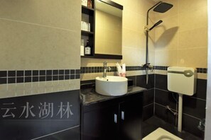 A modern bathroom with a round sink, a handheld showerhead, and a toilet. - Yunshui Hulin Inn Puzhehei (Qiubei)