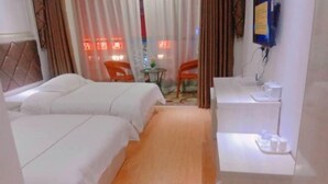 A hotel room with two beds, a small table with a cup, a chair, and a TV mounted on the wall. - Shennongjia Meets Miss Meow Hotel (Shennongjia)