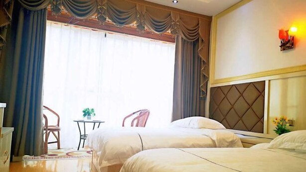 A hotel room with two beds, a small table with chairs, and a large window with curtains. - Shennongjia Meets Miss Meow Hotel (Shennongjia)