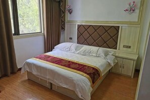 A single bed with a headboard, a bedside table, and a wardrobe in a room with wooden flooring. - Shennongjia Meets Miss Meow Hotel (Shennongjia)