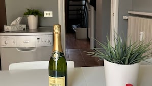 A bottle of Bellerive champagne on a table with a potted plant beside it. - [ISOLA] Loft Taramelli (Milano)
