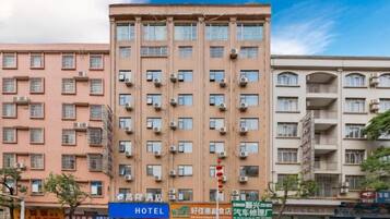 A multi-story hotel with a uniform facade, air conditioning units, and a clear blue sky.