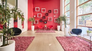 A modern interior with a red wall, multiple framed pictures, and potted plants. - "Live life to the fullest in the heart of Santiago"! (Santiago)